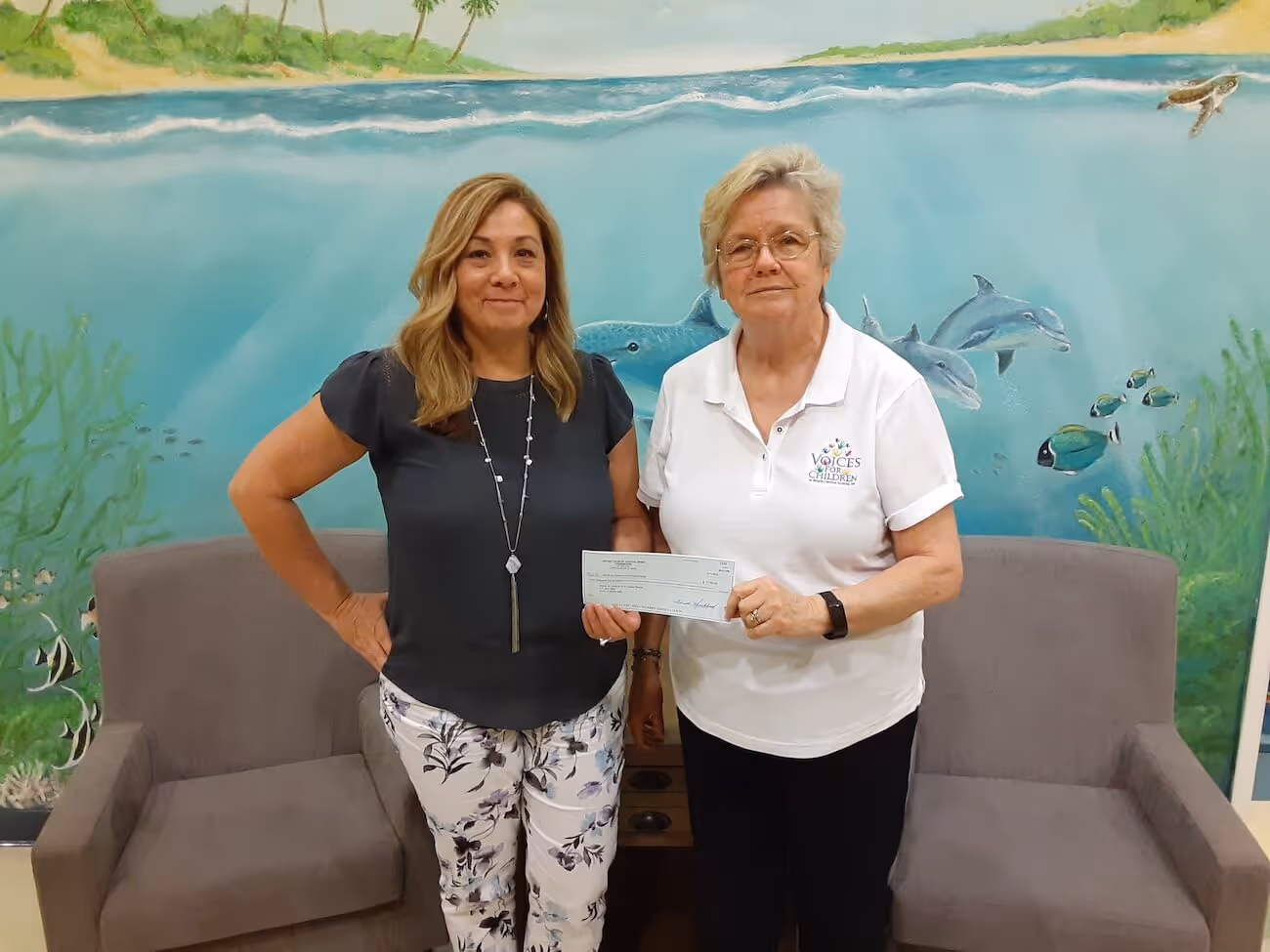Melissa Bowermaster (l) President of the Crystal River Rotary Club presents a check to Kathleen Cossey (r) of Voices for Children