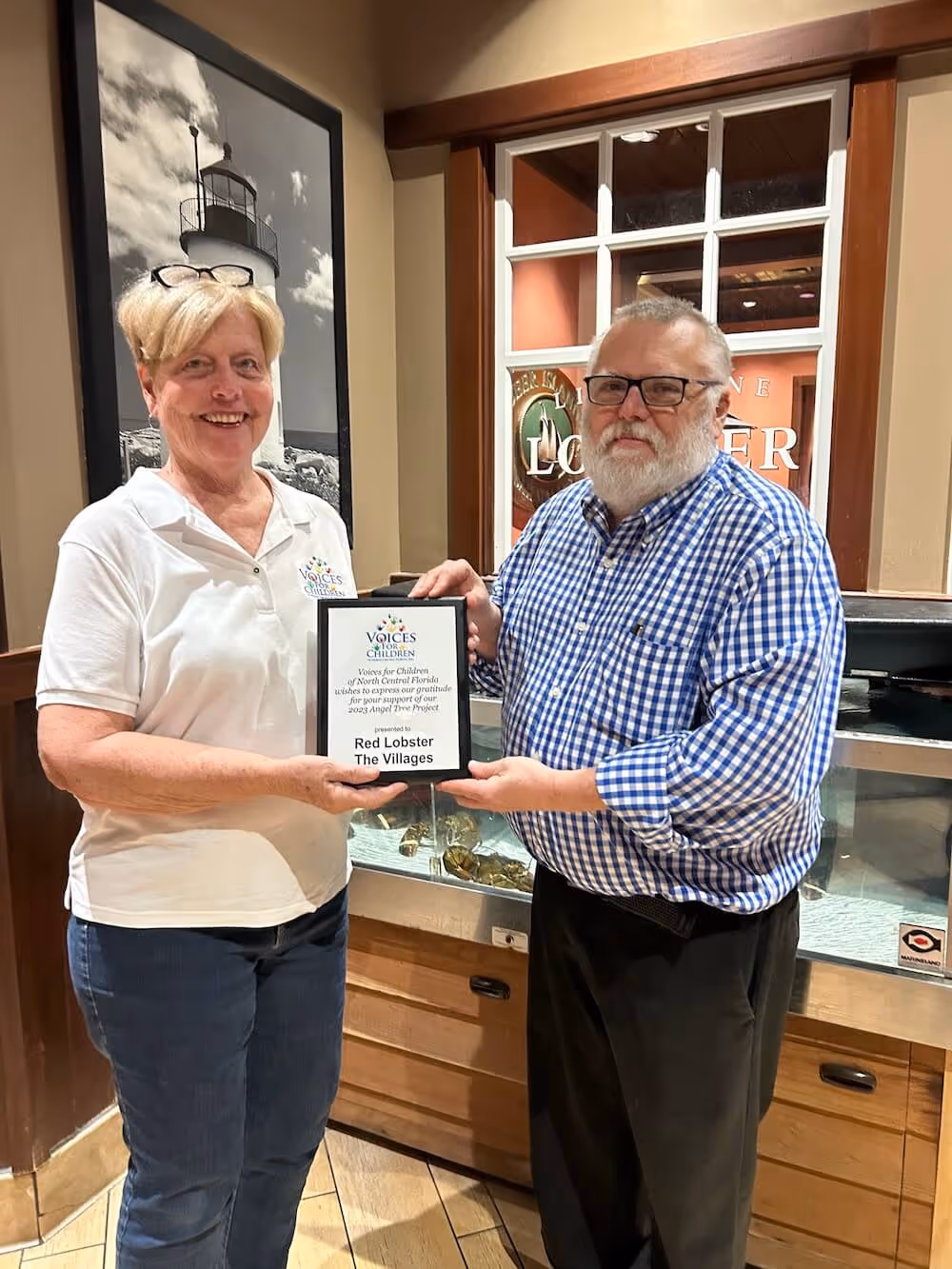 Ray Bozeman from the restaurant accepting a token of appreciation from Dorothy Norman of Voices for Children