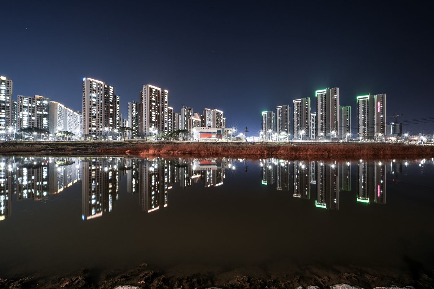 Samyang AF 14-24mm F2.8 FE nachtfoto van stadsgezicht met wolkenkrabbers en reflectie in water