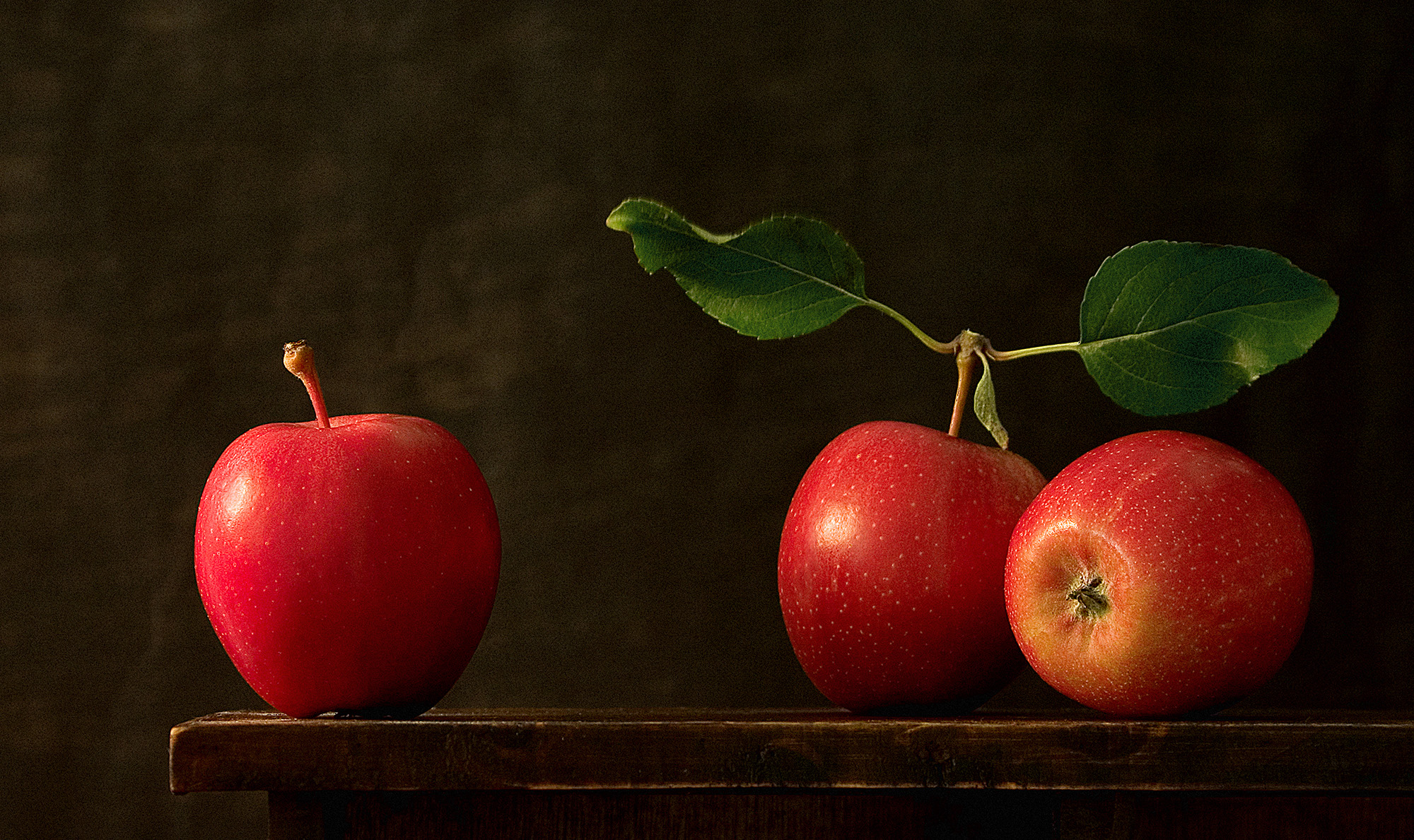 foto van drie rode appels op een tafel