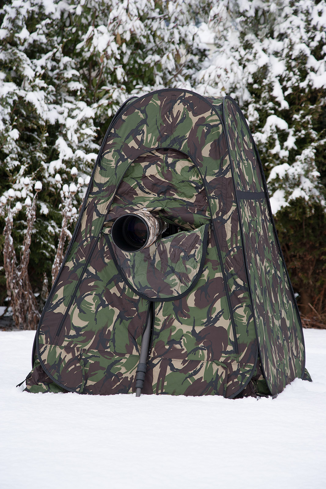 foto van een camouflagetent met camera in de sneeuw