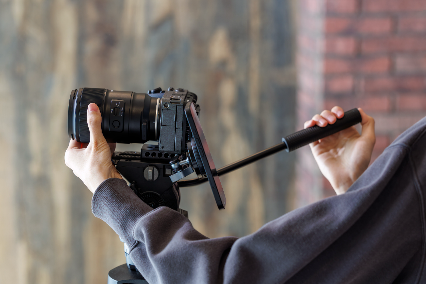 Camerarig met Tamron-objectief en monitor, bediend met een follow-focus handgreep voor video-opnames.