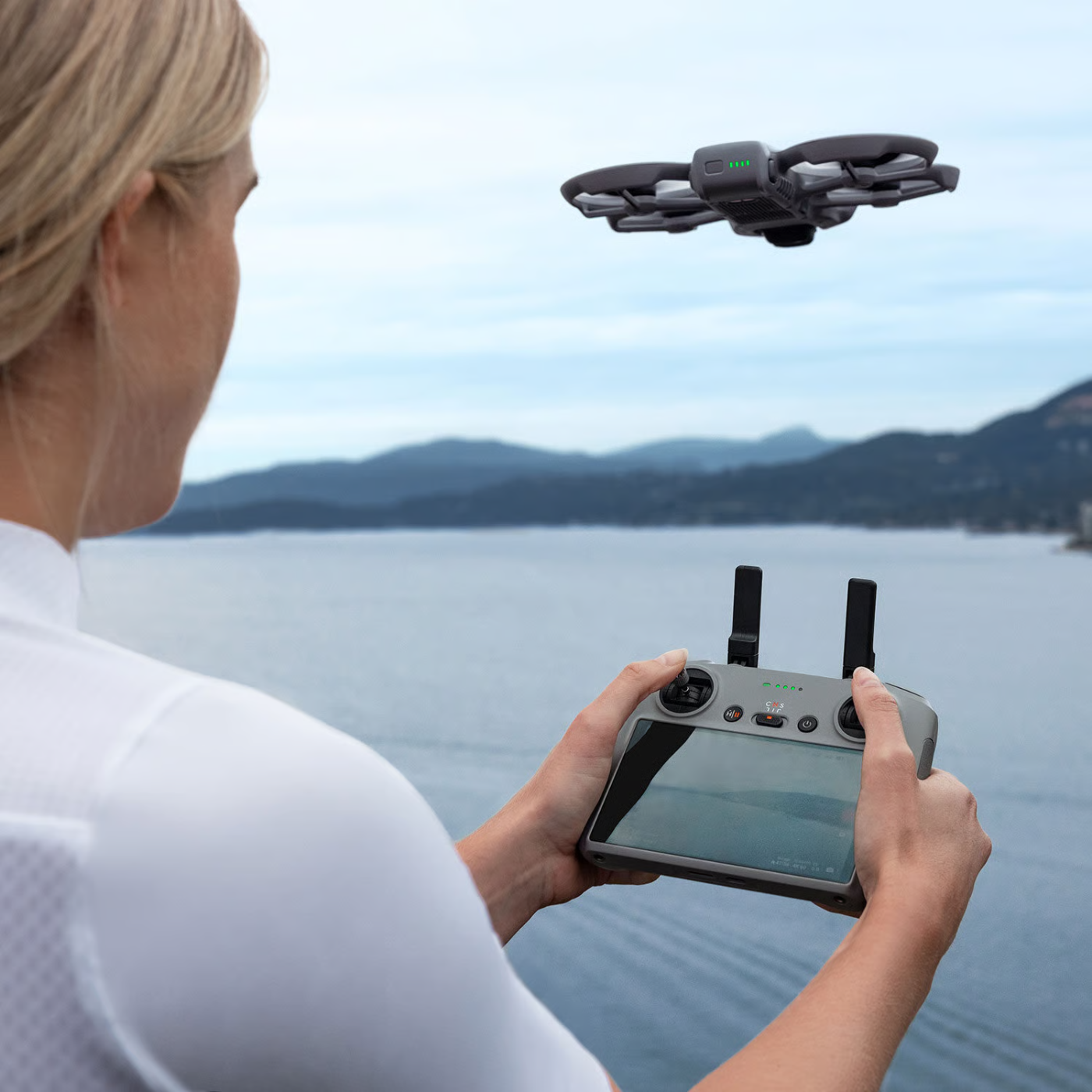 DJI Avata 360 drone in vlucht boven het water, bestuurd met een smart controller met ingebouwd scherm