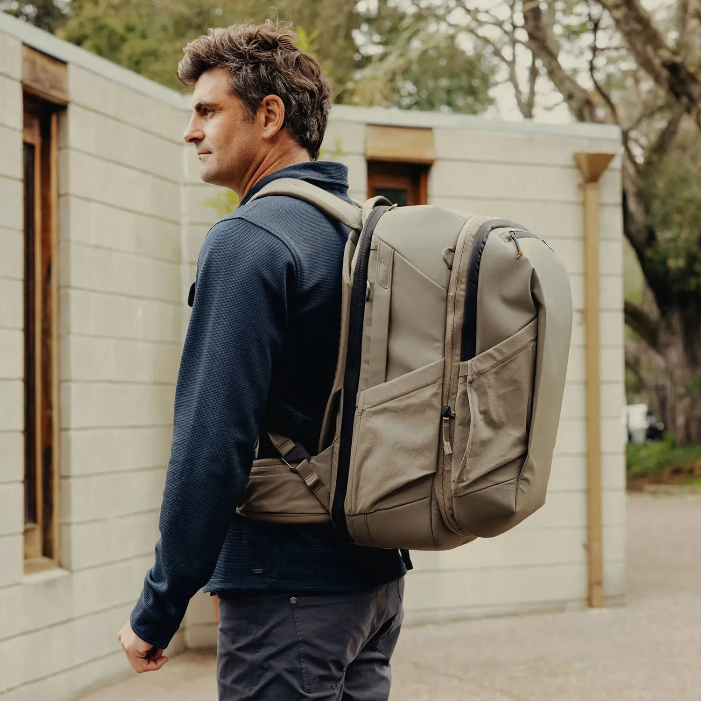 Man draagt de Peak Design Travel Backpack 2-in-1 als complete modulaire reisrugzak op zijn rug.