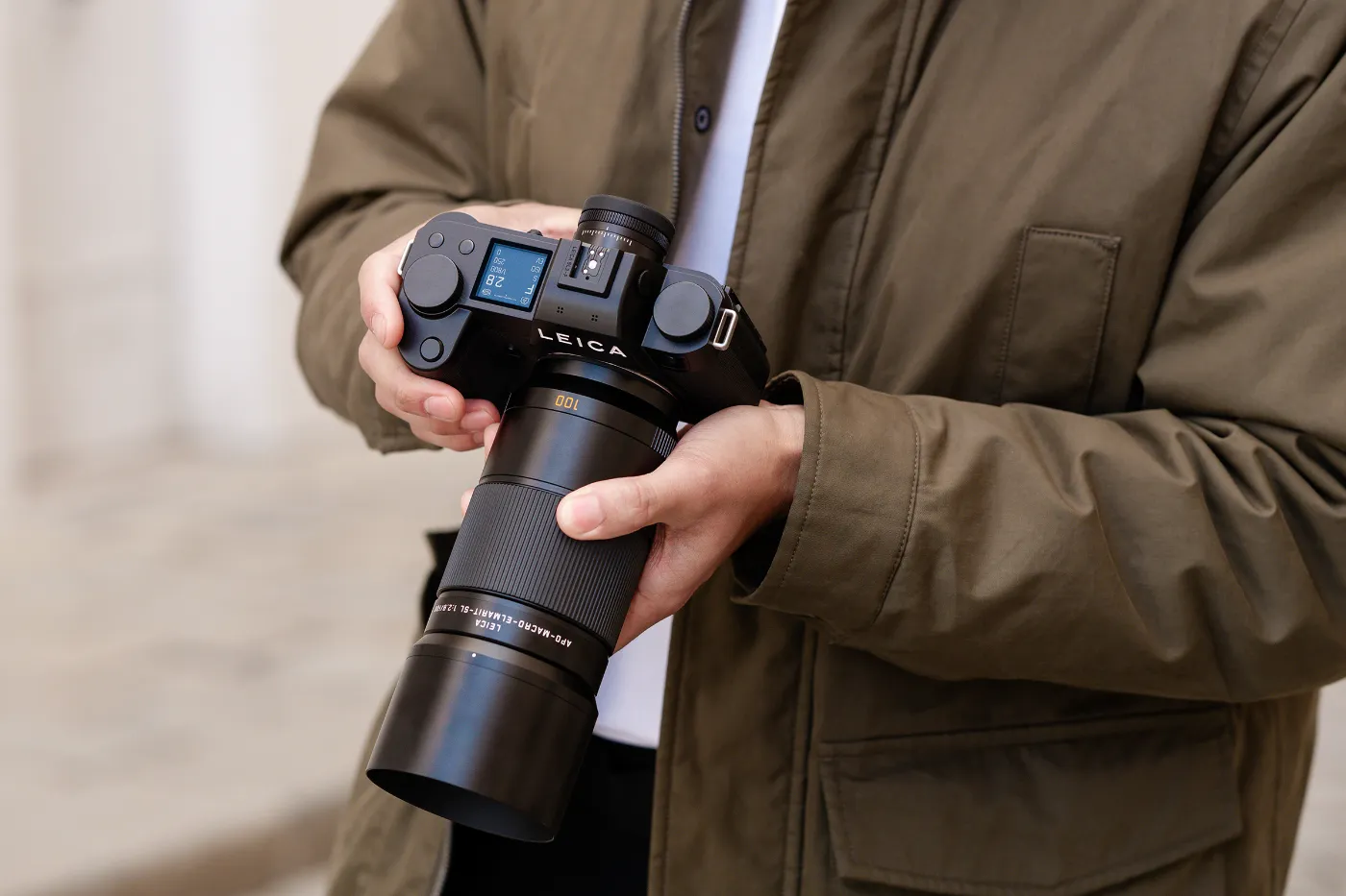 Fotograaf houdt de Leica SL3-P vast met APO-Macro-Elmarit-SL 100mm f/2.8 objectief