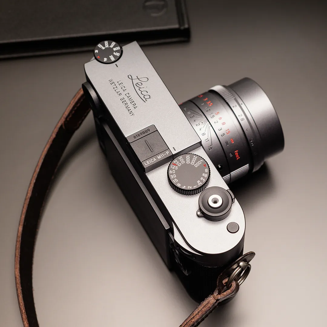 Leica M11-P in metallic grijze lakafwerking met APO-Summicron-M 50mm f/2 ASPH en donkerbruine draagriem