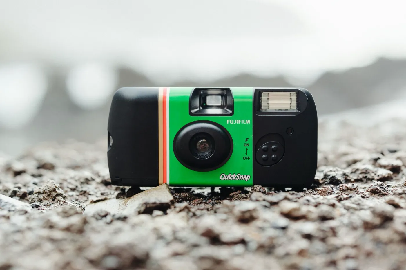 Fujifilm QuickSnap wegwerpcamera met flits liggend op zand of grind