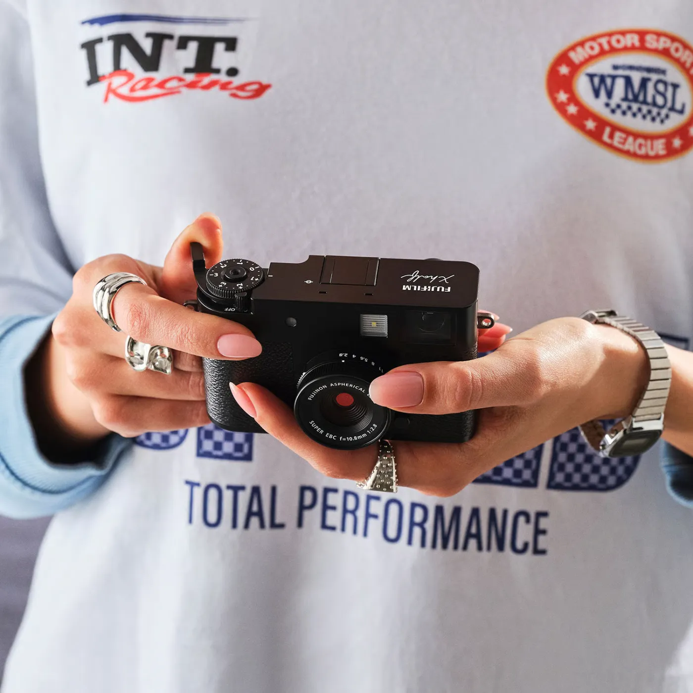 Fujifilm X-half digitale retro compactcamera in handen van sportvrouw