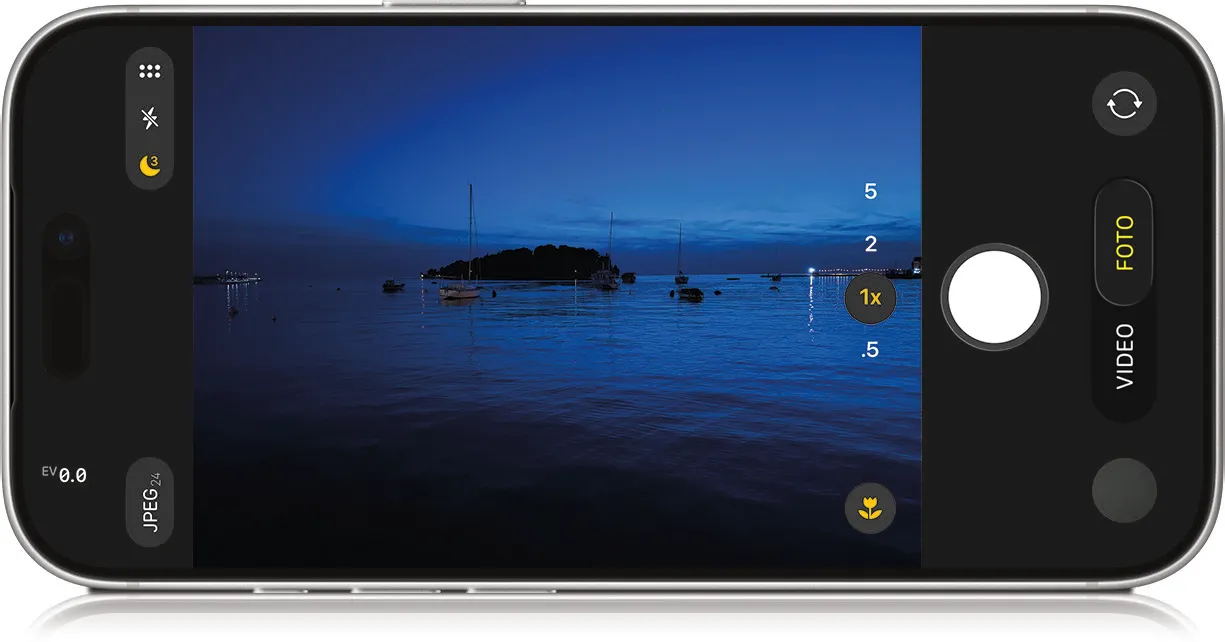 iPhone in liggende stand met de camera-app geopend bij een avondfoto van boten op het water