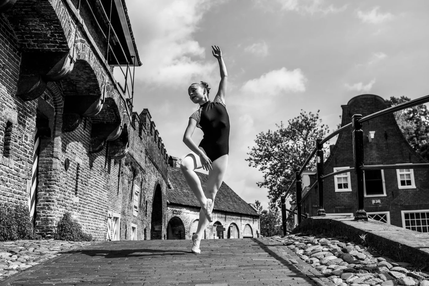 Zwart-witfoto van een danseres bij een bakstenen muur in Amersfoort.