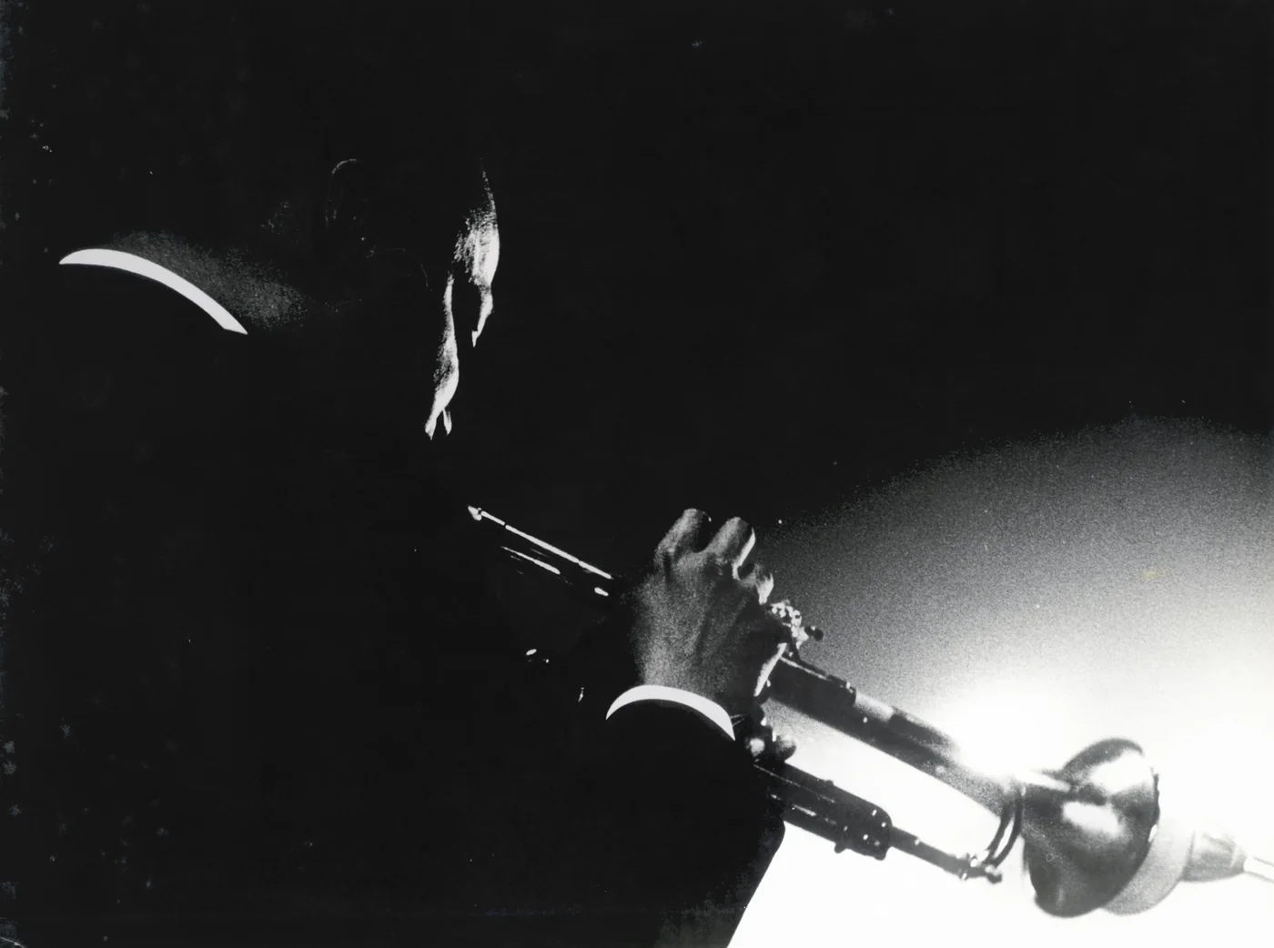 Zwart-witfoto van Miles Davis die trompet speelt, gefotografeerd door Nico van der Stam.