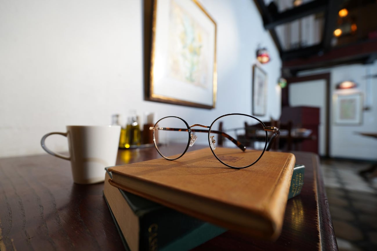 Bril op boeken in een café, gefotografeerd met de Sony FE PZ 16-35mm F4 G