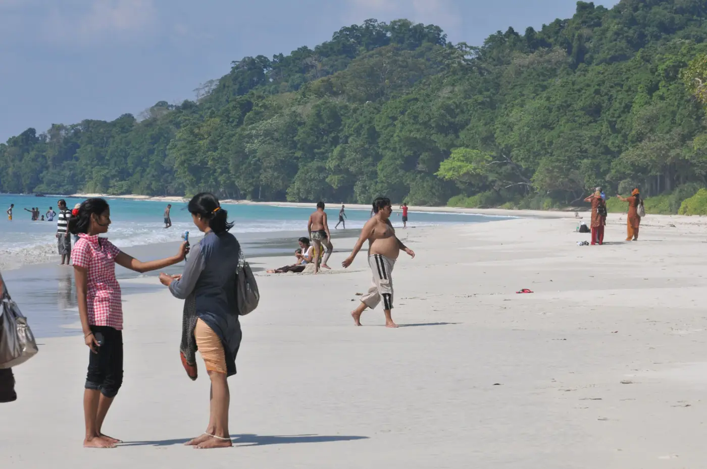 Mensen op een breed strand met jungle op de achtergrond op Havelock
