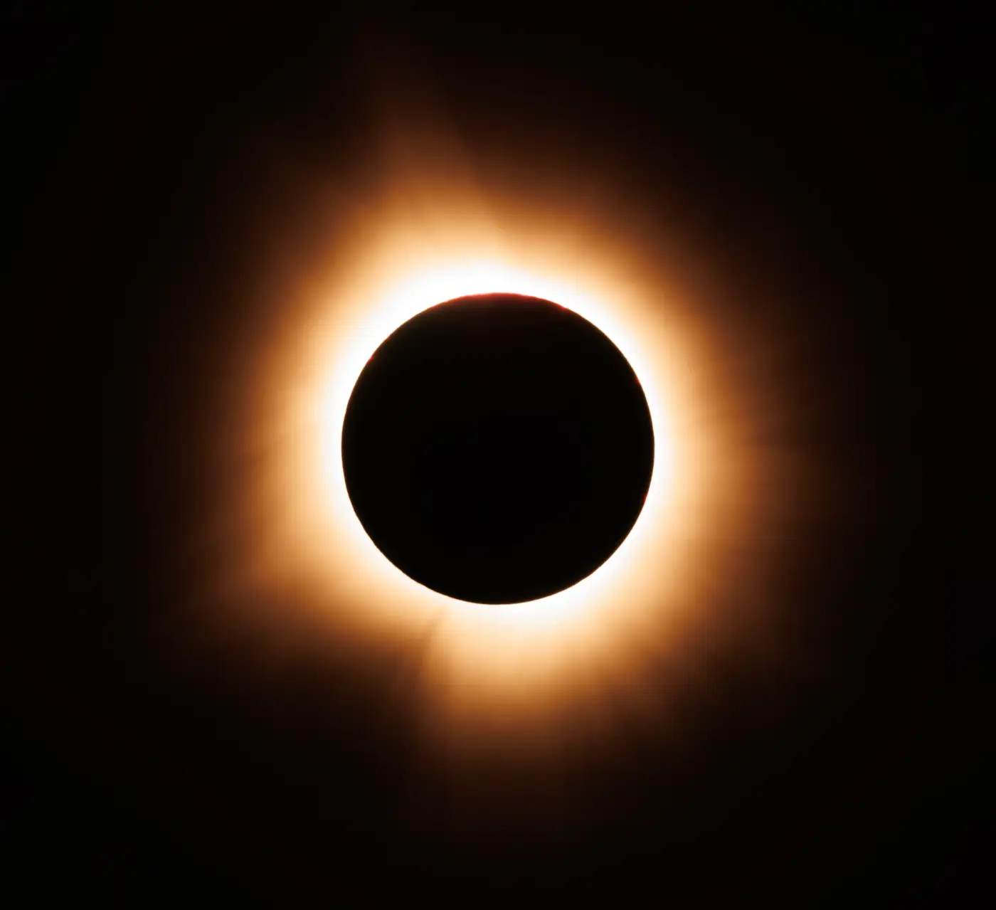Totale zonsverduistering met oranje lichtkrans rond een donkere maanschijf