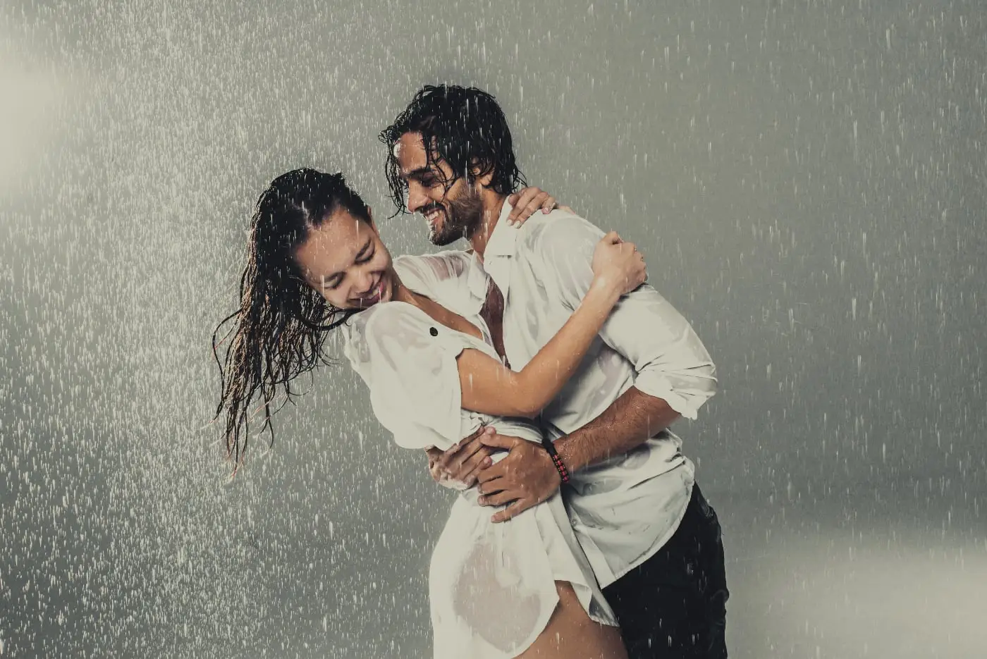 Lachend stel poseert samen in de regen tijdens een creatieve fotoshoot.