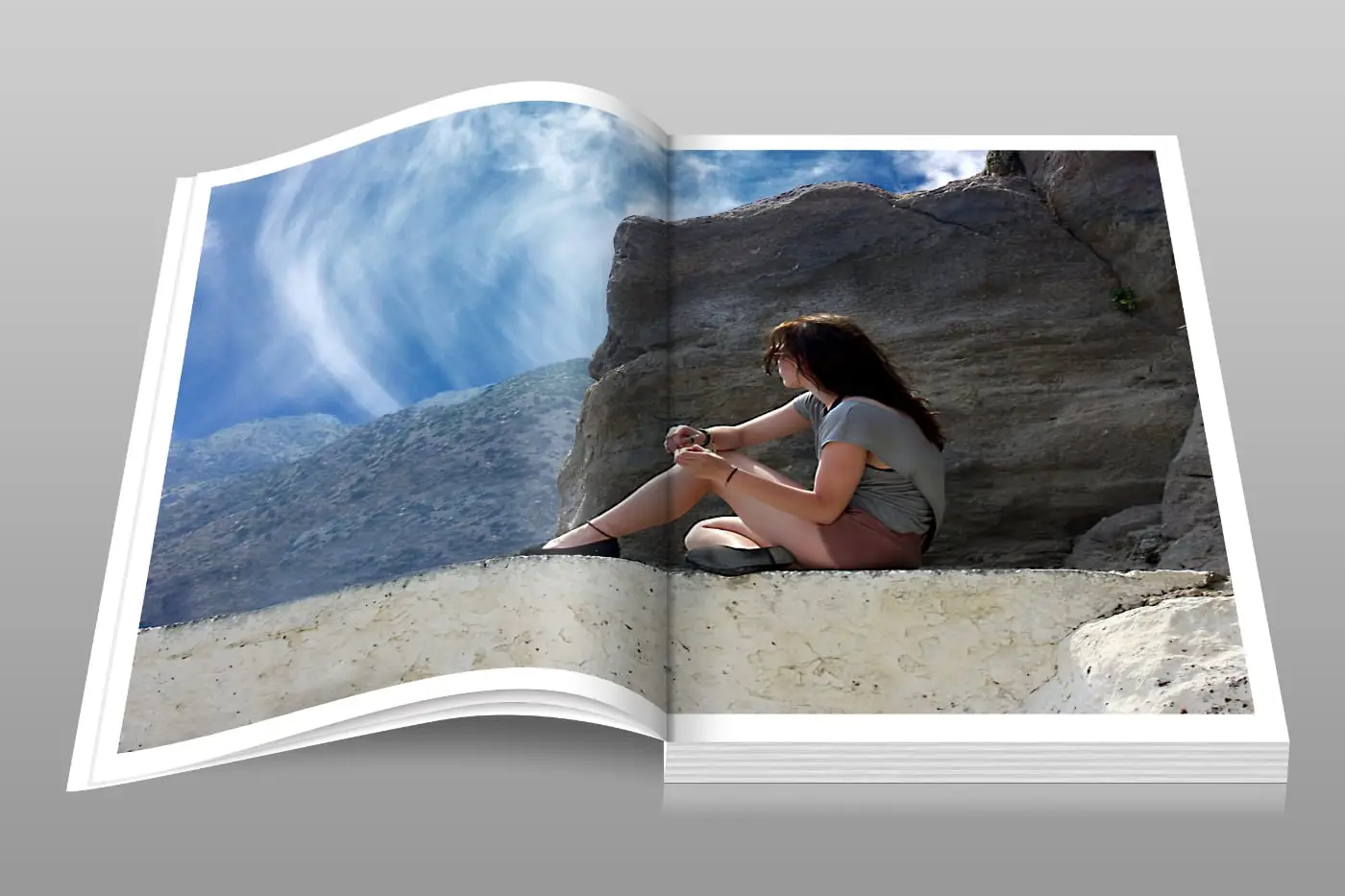 Open fotoboek met foto van een vrouw in een berglandschap