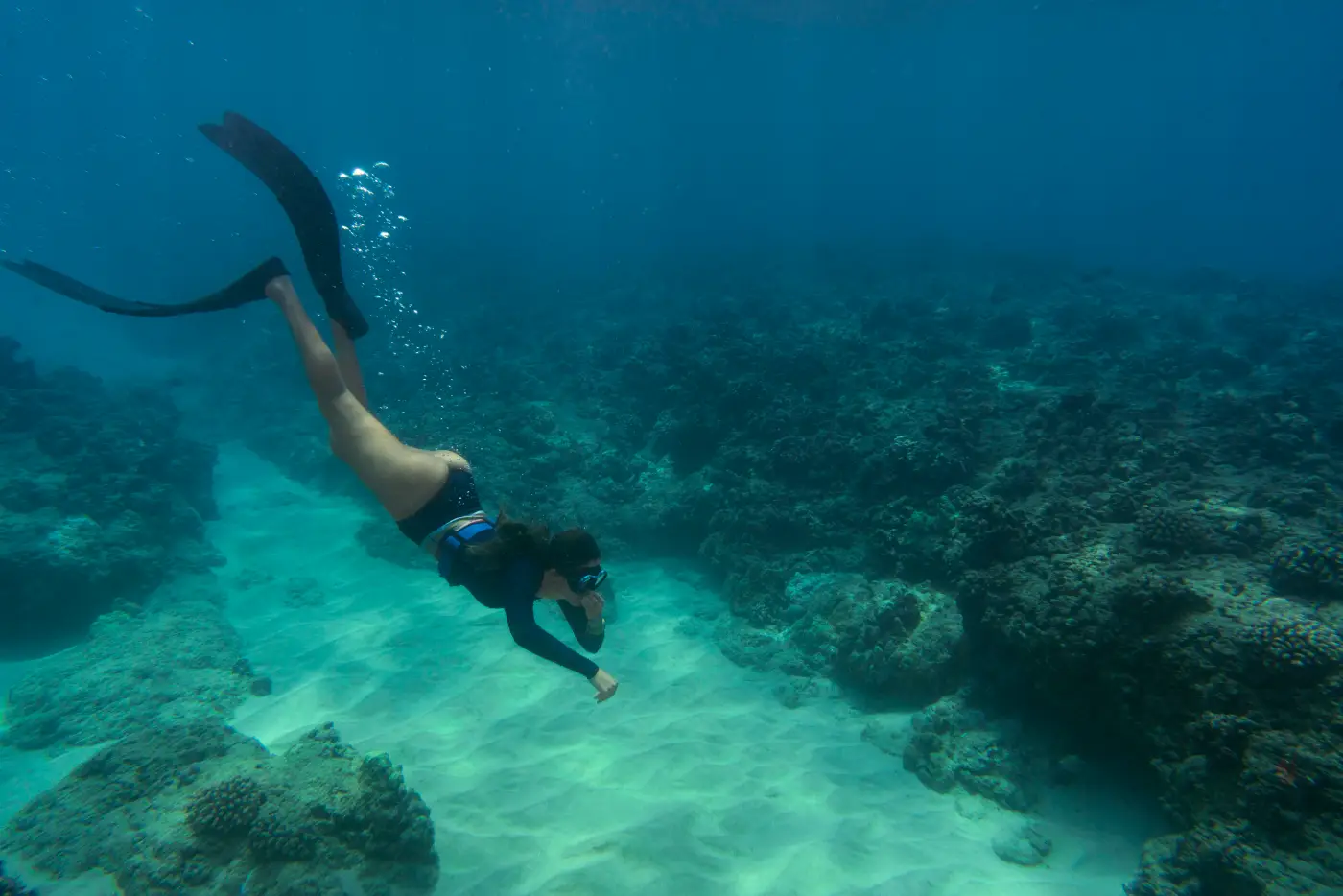 Woman freediving underwater with fins