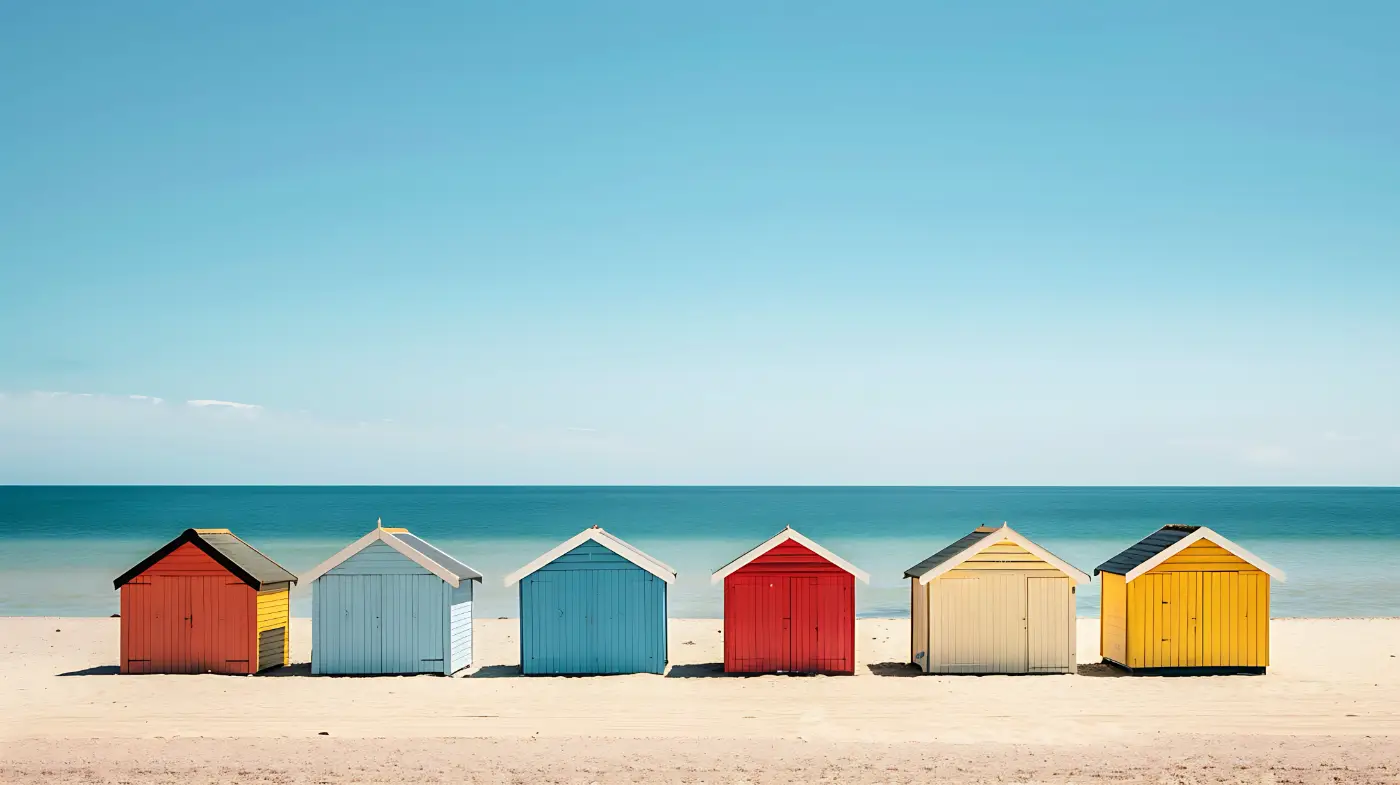 Kleurrijke strandhuisjes op een rustig strand met blauwe zee en lucht