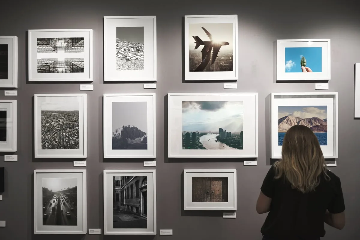 Woman looks at framed photos in a gallery