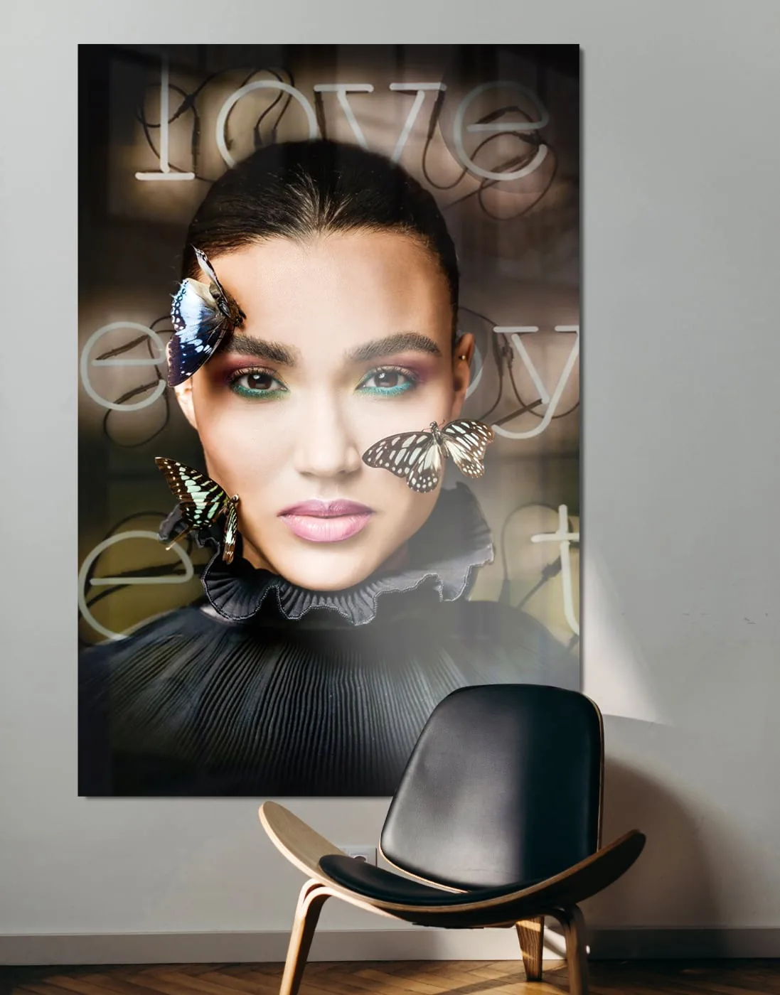 Artistiek modeportret met vlinders en neontekst op groot plexiglas wandkunstwerk naast designstoel