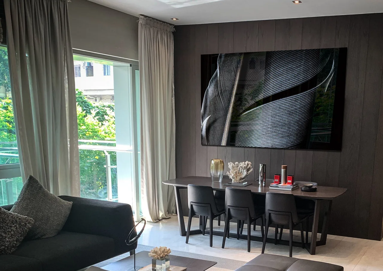 Abstracte zwart-wit fine art foto op plexiglas in modern donker interieur met houten wand en designmeubels