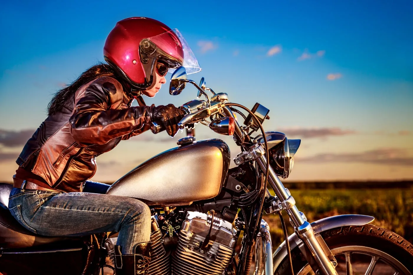 Motorcyclist with red helmet and leather jacket on a motorcycle