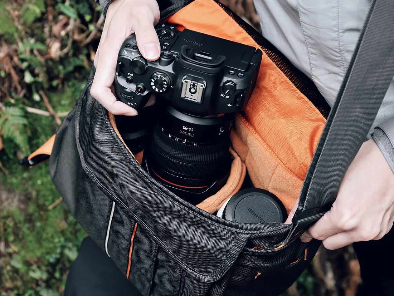 Person takes a Canon camera from a padded camera bag