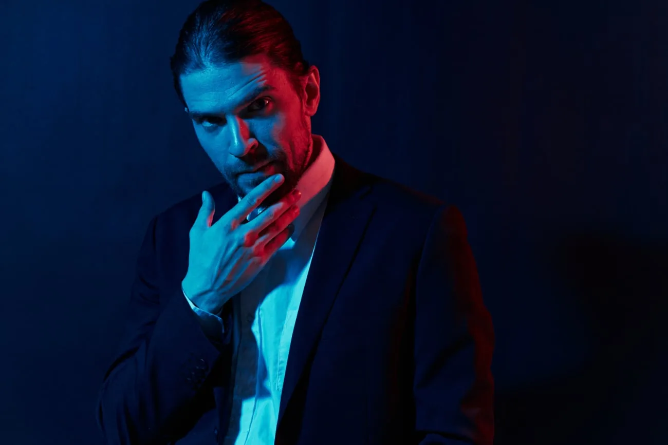 Man in suit illuminated with blue and red light