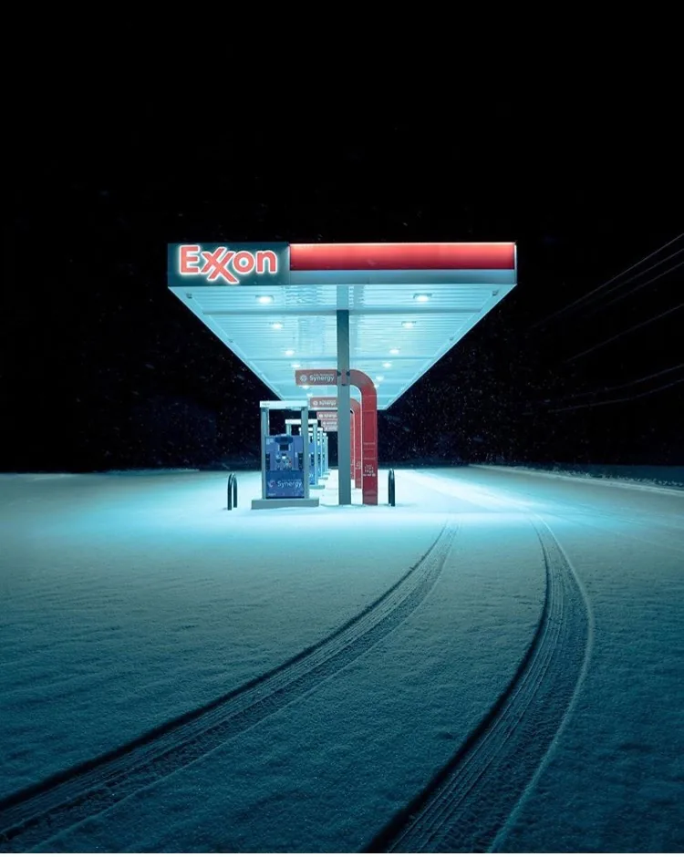 Abandoned Exxon gas station in the snow at night