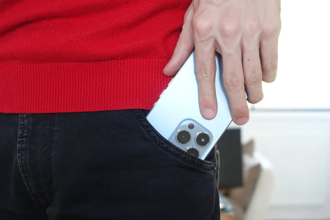 man puts smartphone in pocket