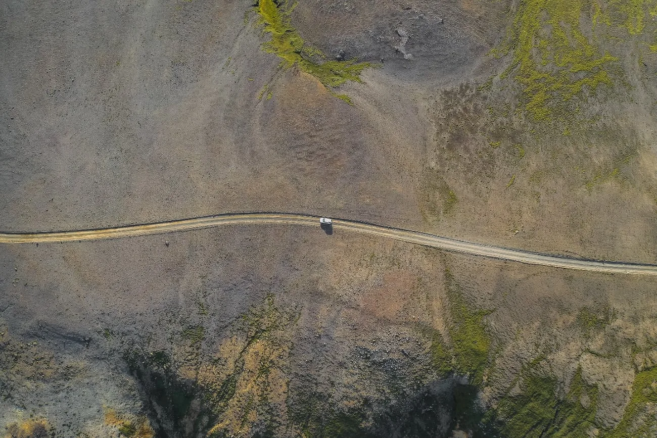 Auto op een landelijke weg vanuit de lucht gefotografeerd met een drone