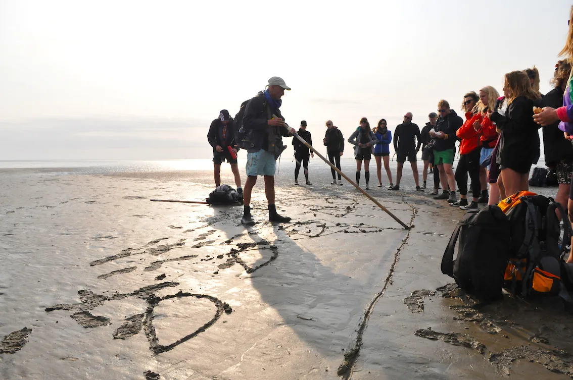 wadloop fotografie workshop op wadden met fotograaf Tom van der Leij - uitleg aan groep op het natte zand