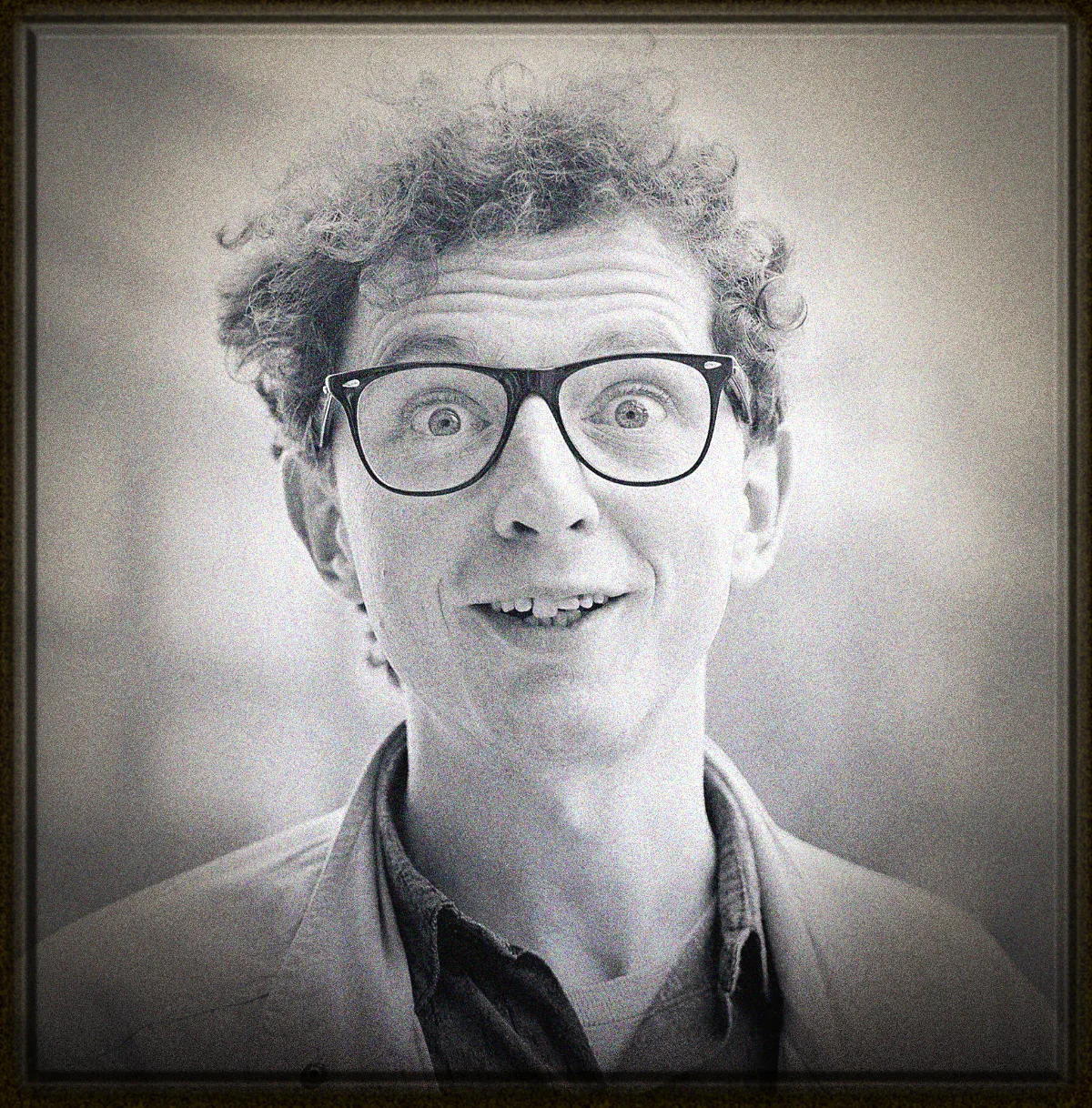 Black and white portrait of a surprised man wearing glasses
