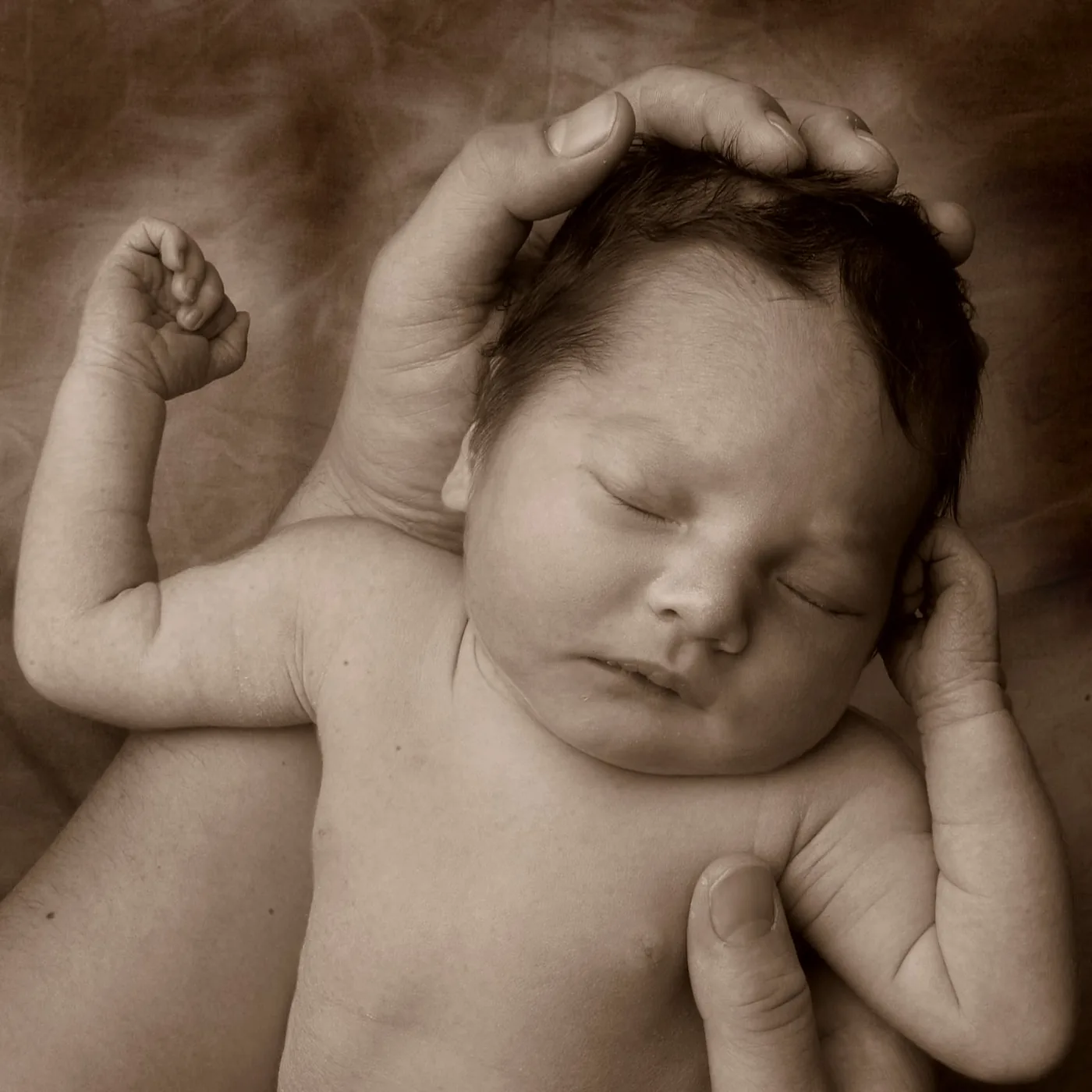 slapende pasgeboren baby in handen close up door fotograaf Alex de Smit