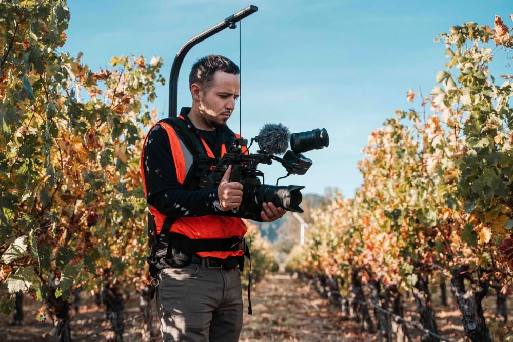 videograaf buiten in boomgaard aan het filmen