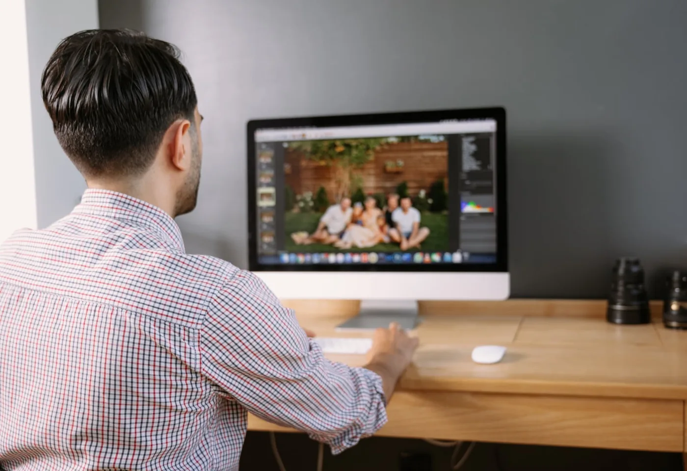 Photographer edits a group photo on a desktop computer