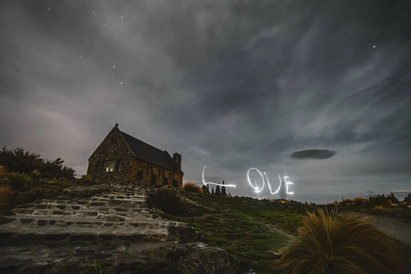 Lightpainting huis op heuvel met tekst Love in de lucht