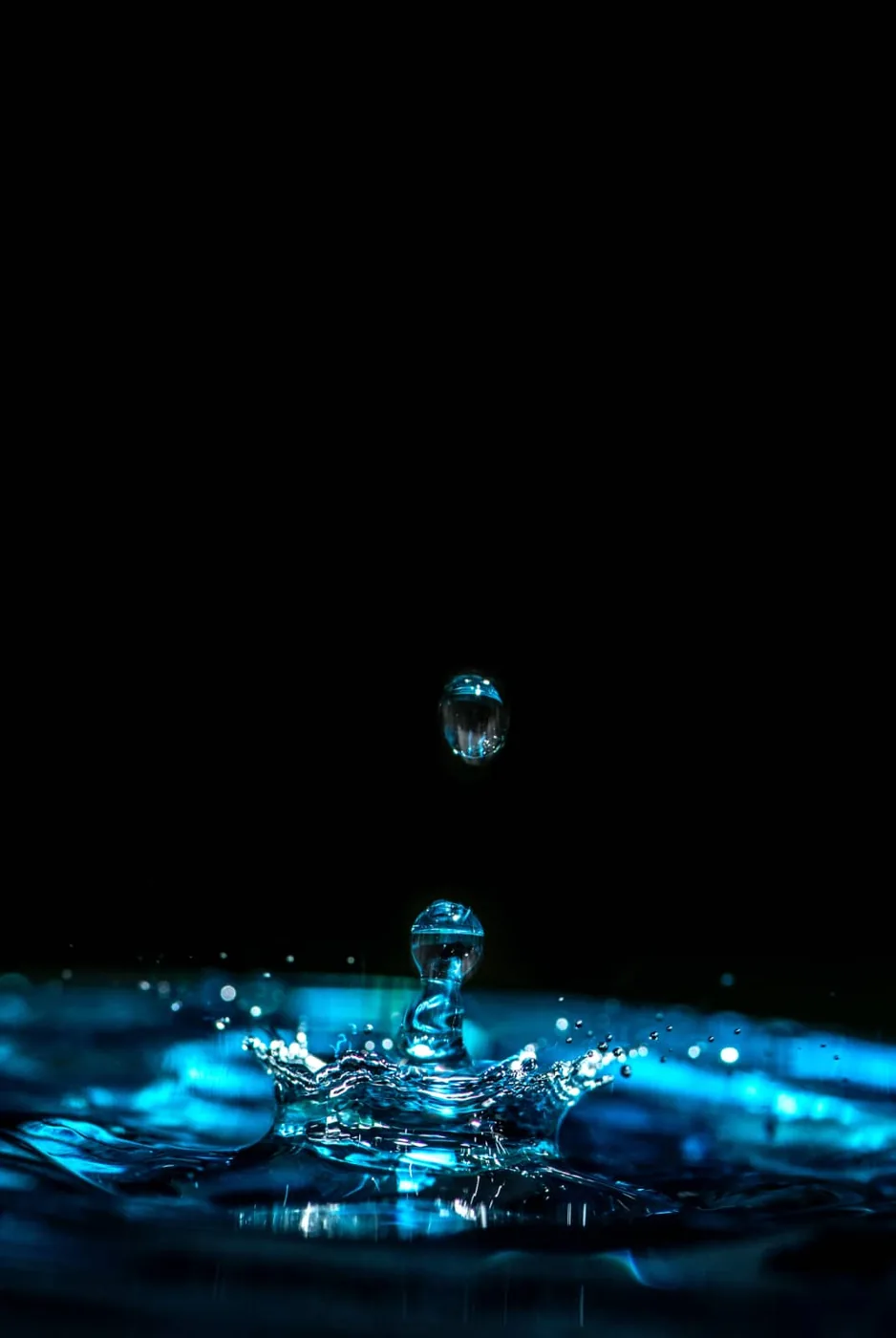 foto: erda estremera - unsplash, druppel op blauw water in zwart