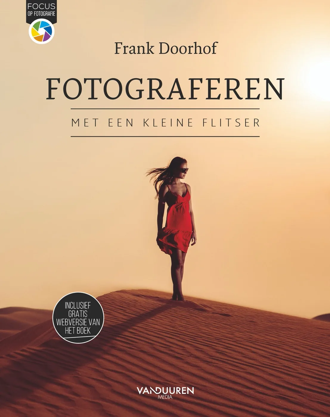 Book cover of Fotograferen met een kleine flitser by Frank Doorhof, showing a woman in a red dress on a sand dune; ISBN 9789463561532