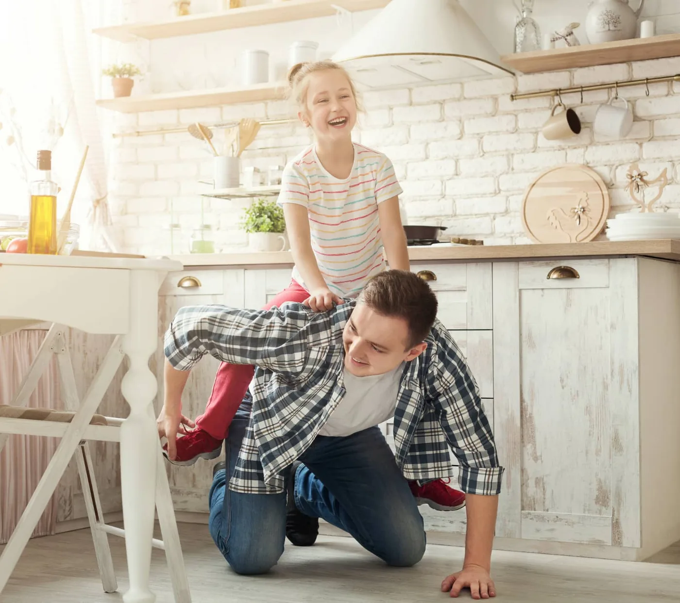 father gives his daughter a horsey ride in the kitchen
