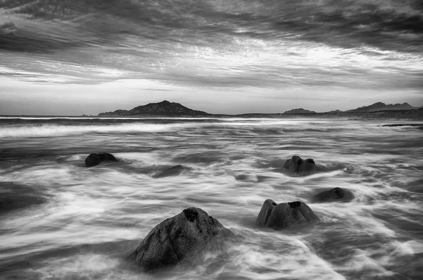 Rocks in the sea with water smoothed by a long exposure.