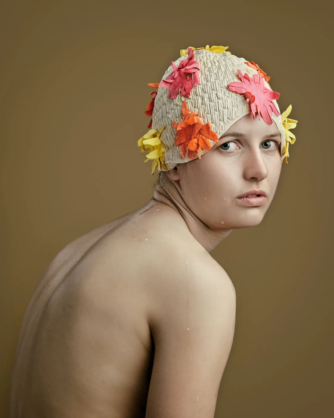 fotoportret van zwemster met badmuts op met roze oranje en gele bloemen
