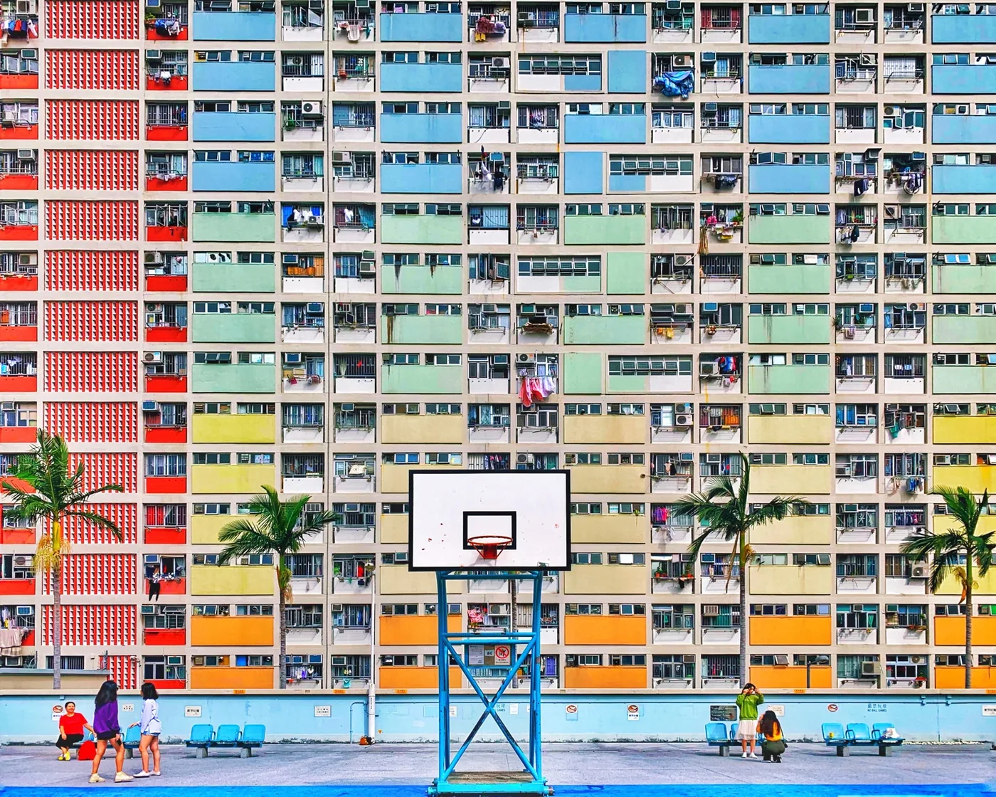 Colorful apartment building with a square and basketball hoop in front