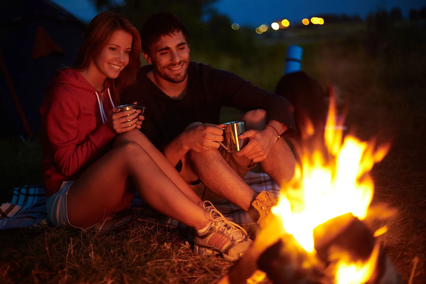 man en vrouw bij kampvuur in avond