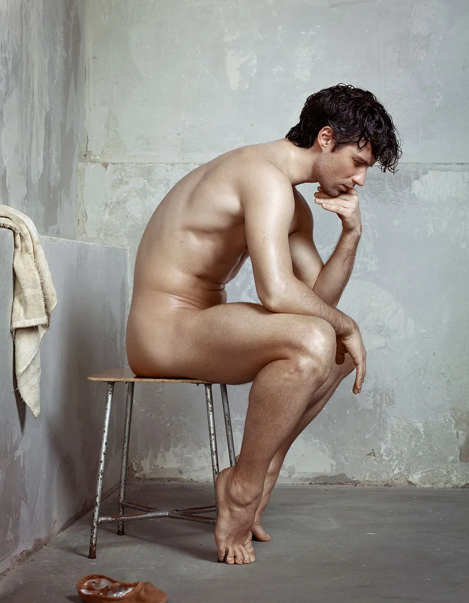 foto van Erwin Olaf van zijkant van naakte jonge man die op een kruk zit en met zijn kin op zijn hand steunt