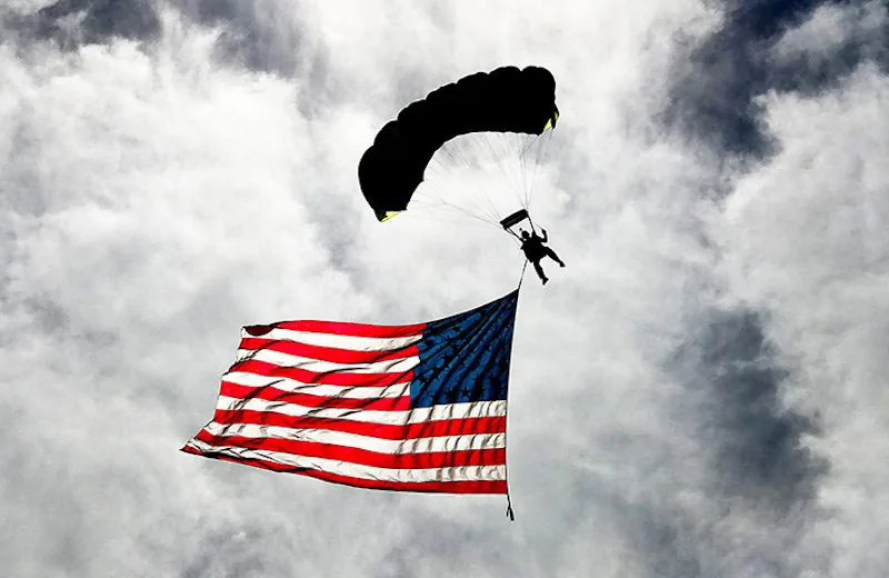 foto van parachutespringer in lucht met Amerikaanse vlag