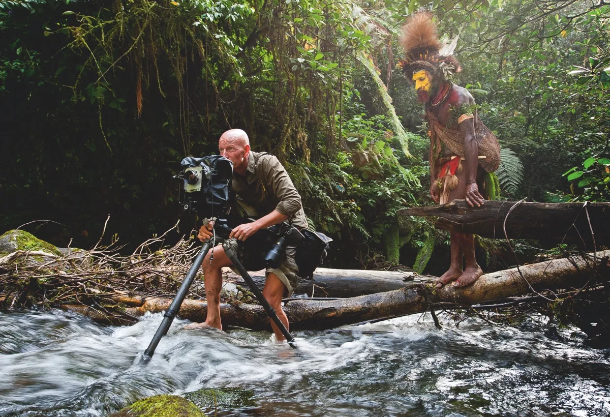 foto van Jimmy Nelson aan het werk met camera in water in oerwoud