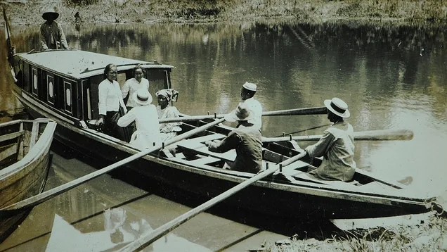 Deze foto komt uit de collectie van het Stichting Surinaams Museum en is gedigitaliseerd in samenwerking met het Nationaal Historisch Museum, Tentboot met roeiers.