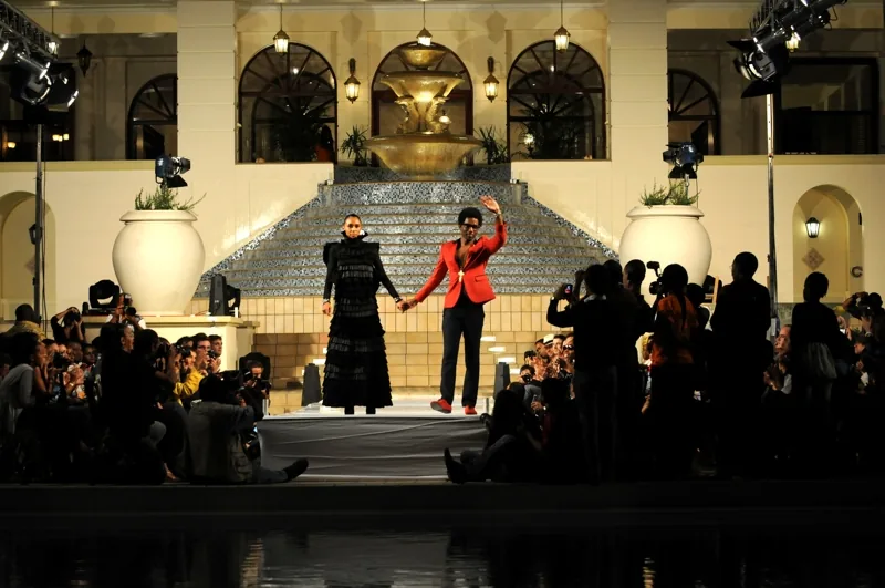 Ontwerpers nemen applaus in ontvangst aan het einde van een modeshow in Mozambique