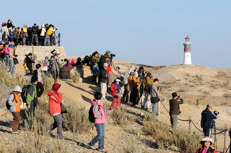 Group of tourists photograph a lighthouse in western China